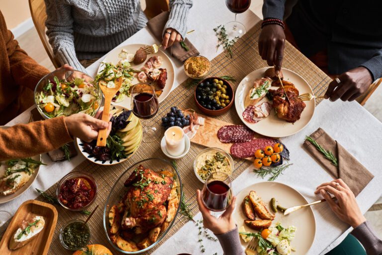 Diverse group of friends enjoying homemade food at festive dinner table